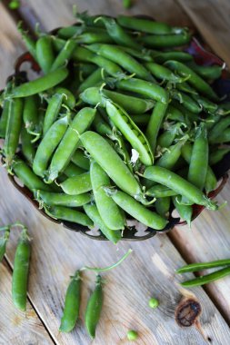Seçici odaklanma. Ahşap bir yüzeyde bir kasede yeşil bezelyeler. Sağlıklı yiyecekler. Vejetaryen diyeti.