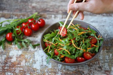 Roka, havuç ve domatesli nefis salata kasesi..