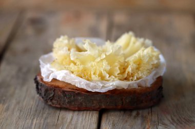 Tahta bir yüzeyde Tete de Moine peyniri.