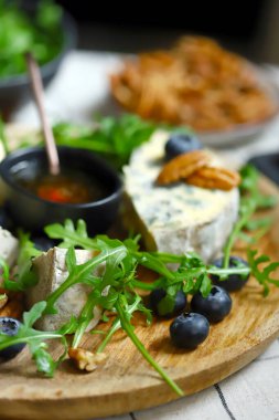 Arugula, fındık, yaban mersini ve tebeşirli Dorblu peynir..