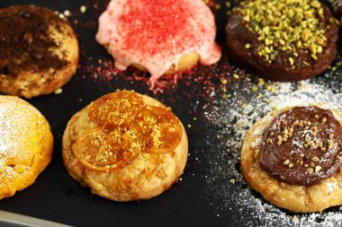 Koyu arkaplanda farklı doldurulmuş kurabiye ve krema.