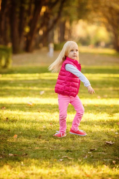 Girl playing   in autumn park.