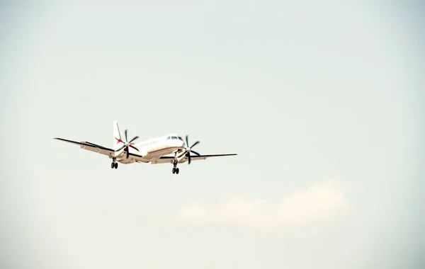 Biplane plane with propellers landing.