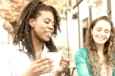 İki hoş genç bayan kahve içiyor. 