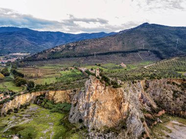 İtalya, Toskana 'da küçük bir tepenin uçurumundaki antik bir kulenin havadan görünüşü.