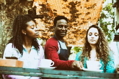 Genç garson iki tatlı kadına servis yapıyor..