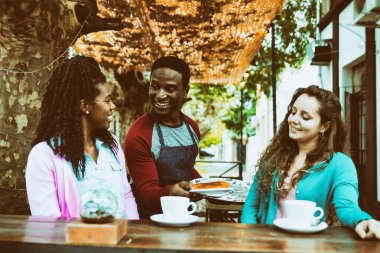 Genç garson iki tatlı kadına servis yapıyor..