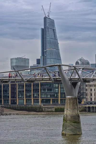Millennium bridge en de skyline van Londen. — Stockfoto