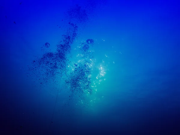 Bubbles on dark background underwater in sea