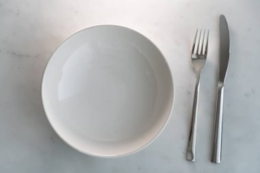 Üst manzara çatal ve bıçak beyaz mermer desenli arka planda. Yemek ve yemek sofra takımı kavramı
