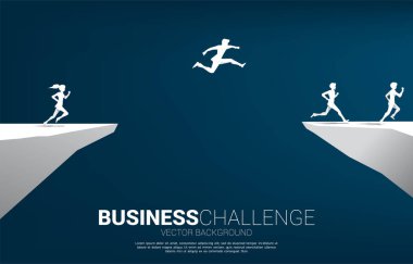 Şehrin arka planında vadinin boşluğundan atlayan iş adamı silueti. İş riski kavramı.