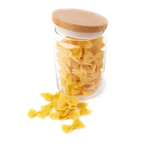 Glazen pot gevuld met droge farfalle pasta over geïsoleerde witte achtergrond — Stockfoto