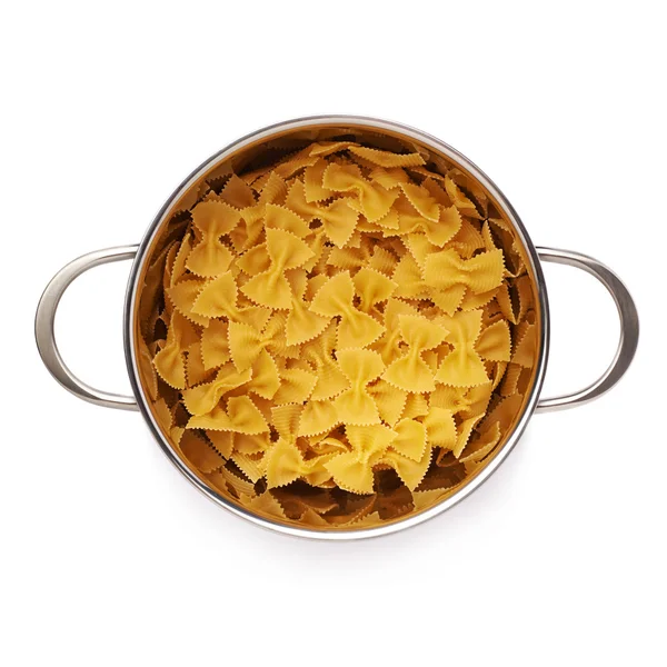 Metal pan filled with dry farfalle pasta over isolated white background — Stock Photo, Image