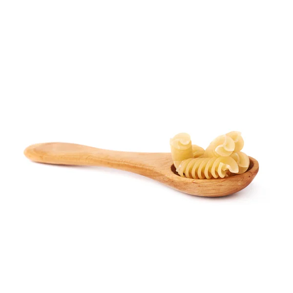 Wooden spoon filled with dry rotini pasta over isolated white background — 스톡 사진