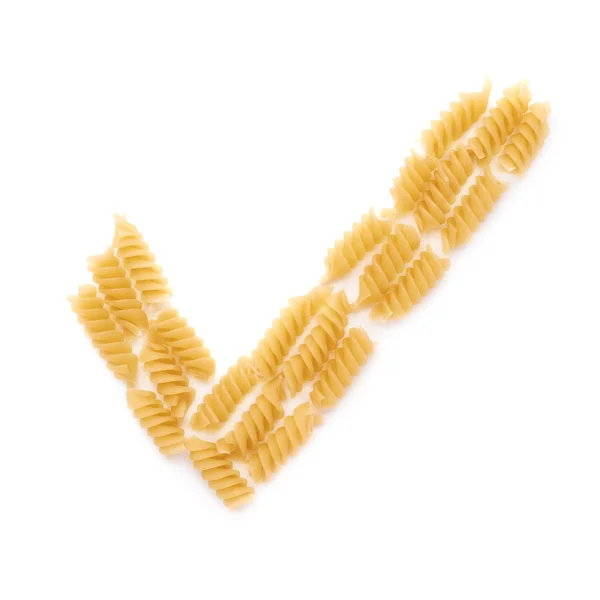 Yes tick sign symbol mark made of dry rotini pasta over isolated white background — Stock Photo, Image