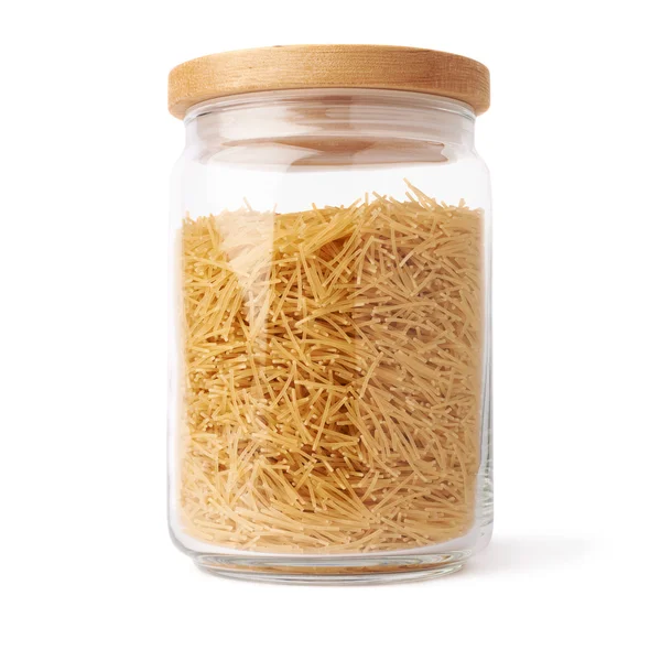 Glazen pot gevuld met droge noedels pasta over geïsoleerde witte achtergrond — Stockfoto
