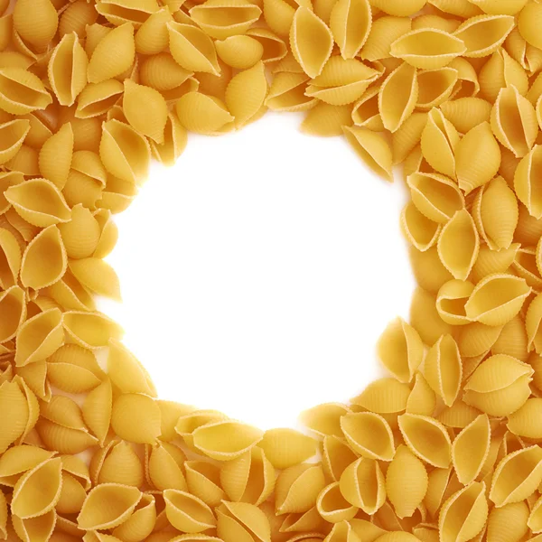Round frame made of dry conchiglie pasta over isolated white background — Stock Photo, Image