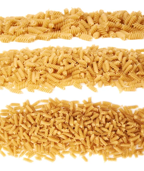 Line made of dry rotini pasta over isolated white background — Stock Photo, Image