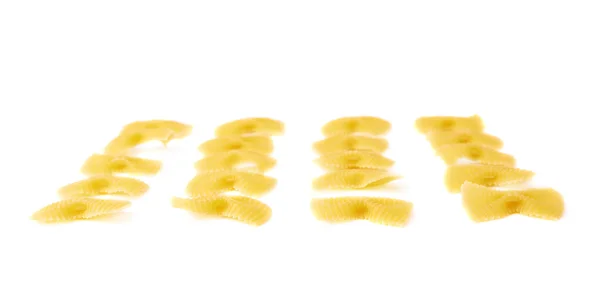 Einzelne Stücke trockener Farfalle-Pasta auf isoliertem weißem Hintergrund — Stockfoto