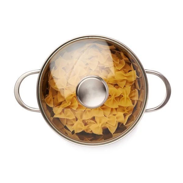 Metallpfanne mit Glasdeckel gefüllt mit trockener Farfalle-Pasta auf isoliertem weißem Hintergrund — Stockfoto