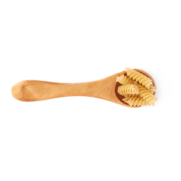 Wooden spoon filled with dry rotini pasta over isolated white background — Zdjęcie stockowe