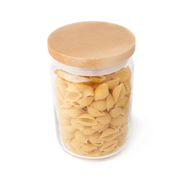 Glass jar filled with dry conchiglie pasta over isolated white background — Stock Photo, Image