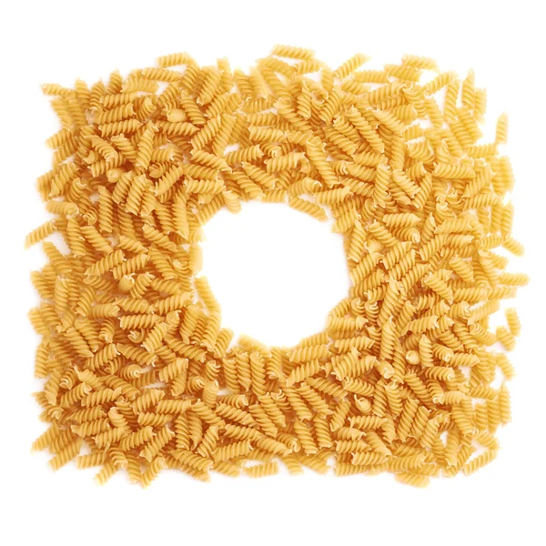 Round frame made of dry rotini pasta over isolated white background — Stock Photo, Image