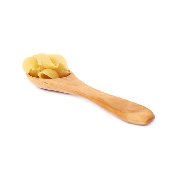 Holzlöffel gefüllt mit trockener Conchiglie-Pasta über isoliertem weißem Hintergrund — Stockfoto