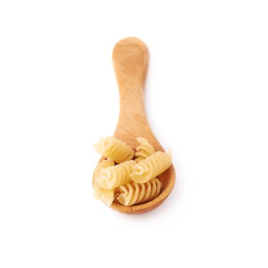 Wooden spoon filled with dry rotini pasta over isolated white background