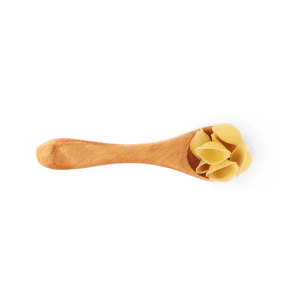 Holzlöffel gefüllt mit trockener Conchiglie-Pasta über isoliertem weißem Hintergrund — Stockfoto