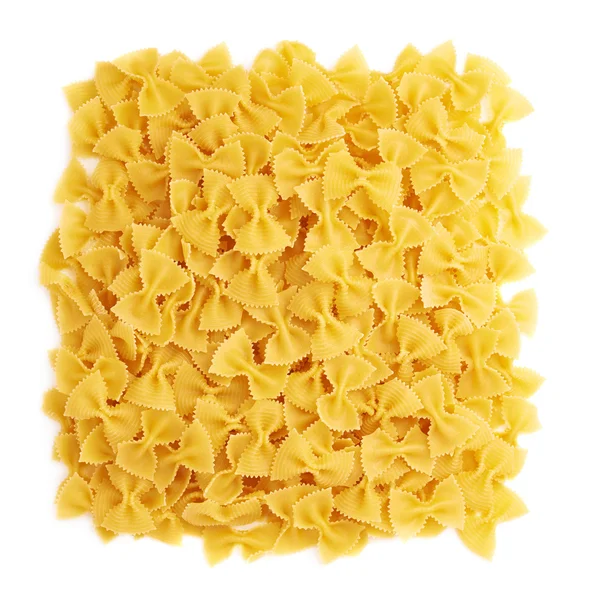 Pile of dry farfalle pasta over isolated white background — Stock Photo, Image