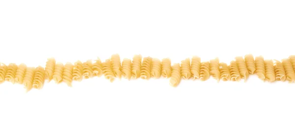 Linie aus trockener Rotini-Pasta über isoliertem weißem Hintergrund — Stockfoto