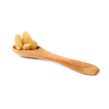 Wooden spoon filled with dry rotini pasta over isolated white background