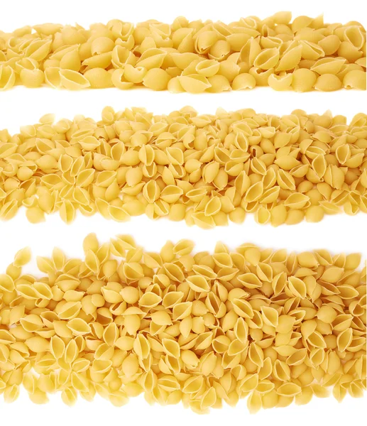 Line made of dry conchiglie pasta over isolated white background — Stock Photo, Image