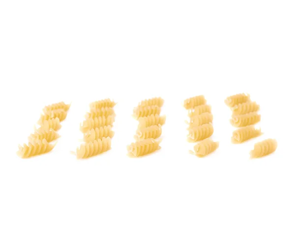 Single pieces of dry rotini pasta over isolated white background — Stock Photo, Image