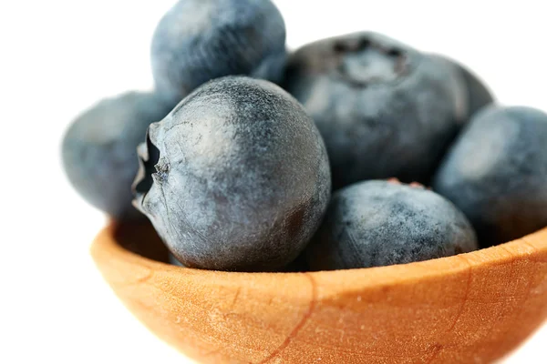 Holzlöffel gefüllt mit Heidelbeere oder Blaubeere über isoliertem weißem Hintergrund — Stockfoto