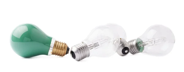 Green bulb lying next to couple of transparent bulbs over white isolated background — Stock Photo, Image