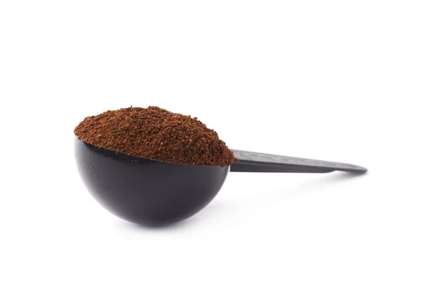 Cuchara dosificadora llena de café sobre fondo blanco aislado — Foto de Stock