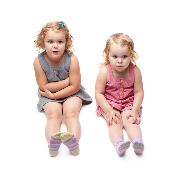 Couple of young little girl sitting over isolated white background — Stock Photo, Image