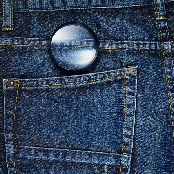 Magnifying glass in jeans — Stock Photo, Image