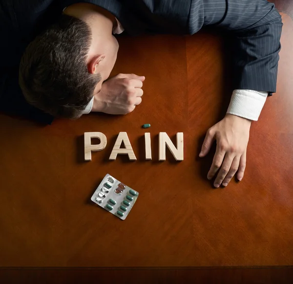 Word Pain and devastated man composition — Stock Photo, Image