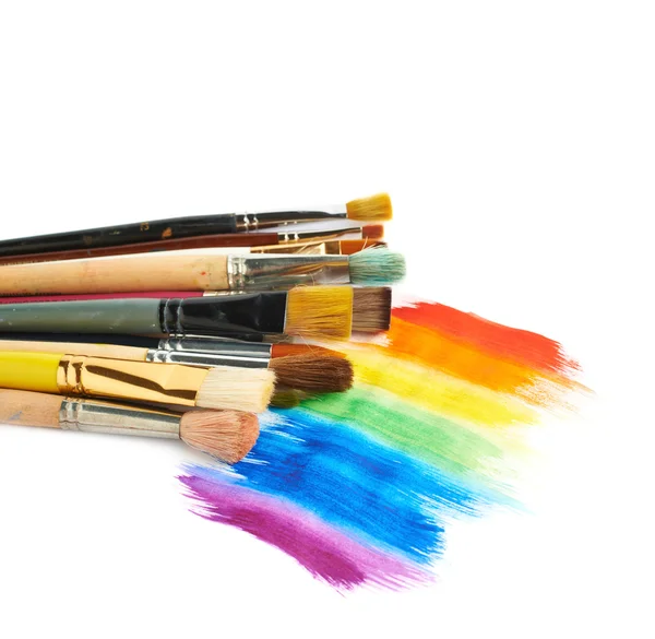 Pile of different brushes over the paint strokes — Stock Photo, Image