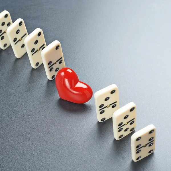 Red heart between the domino pieces — Stock Photo, Image