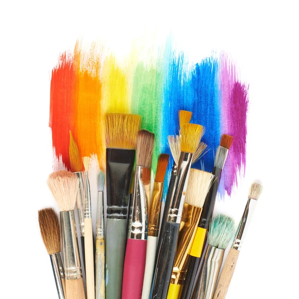 Pile of different brushes over the paint strokes — Stock Photo, Image