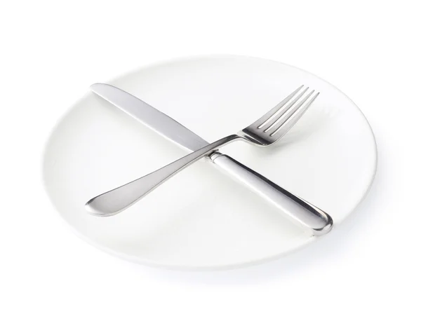 Knife and fork over the plate isolated — Stock Photo, Image