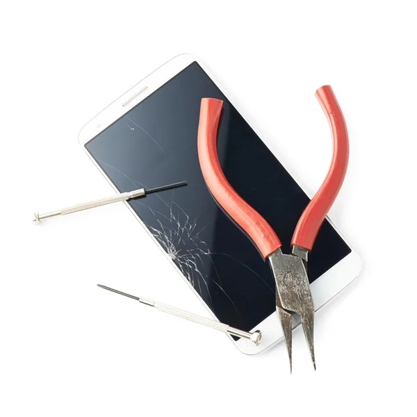Pliers and screwdriver over the broken phone — Stock Photo, Image