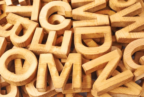 Surface covered with multiple wooden letters — Stock Photo, Image