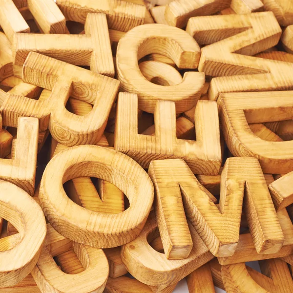 Surface covered with multiple wooden letters — Stock Photo, Image