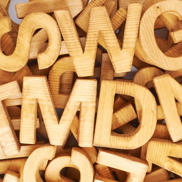 Surface covered with multiple wooden letters — Stock Photo, Image