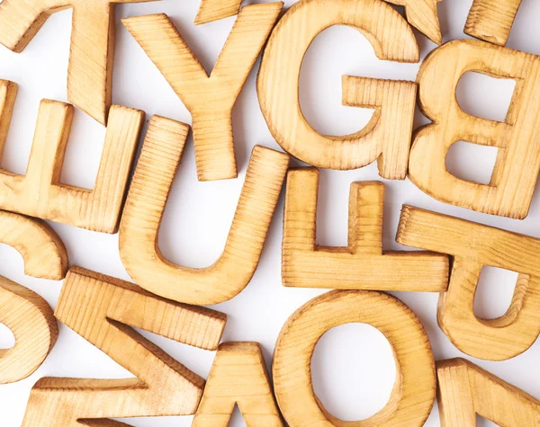 Surface covered with multiple wooden letters — Stock Photo, Image